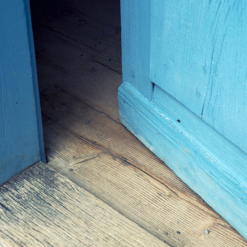 closeup of an open old blue wooden door